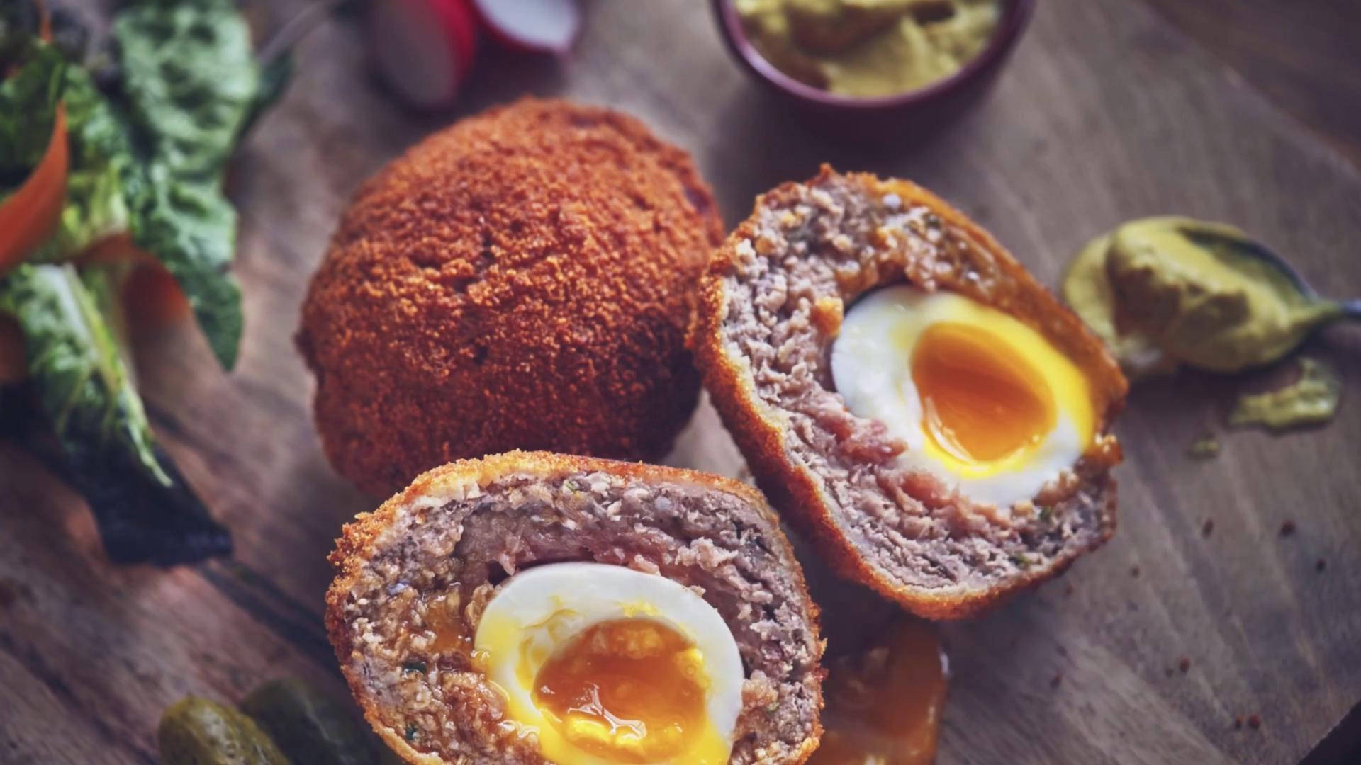 Succulent Traditional British Scotch Eggs garnished with Fresh Green Spinach Wallpaper