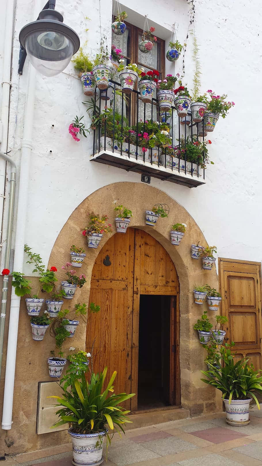 Traditional Spanish Home Entrancewith Flower Pots Wallpaper