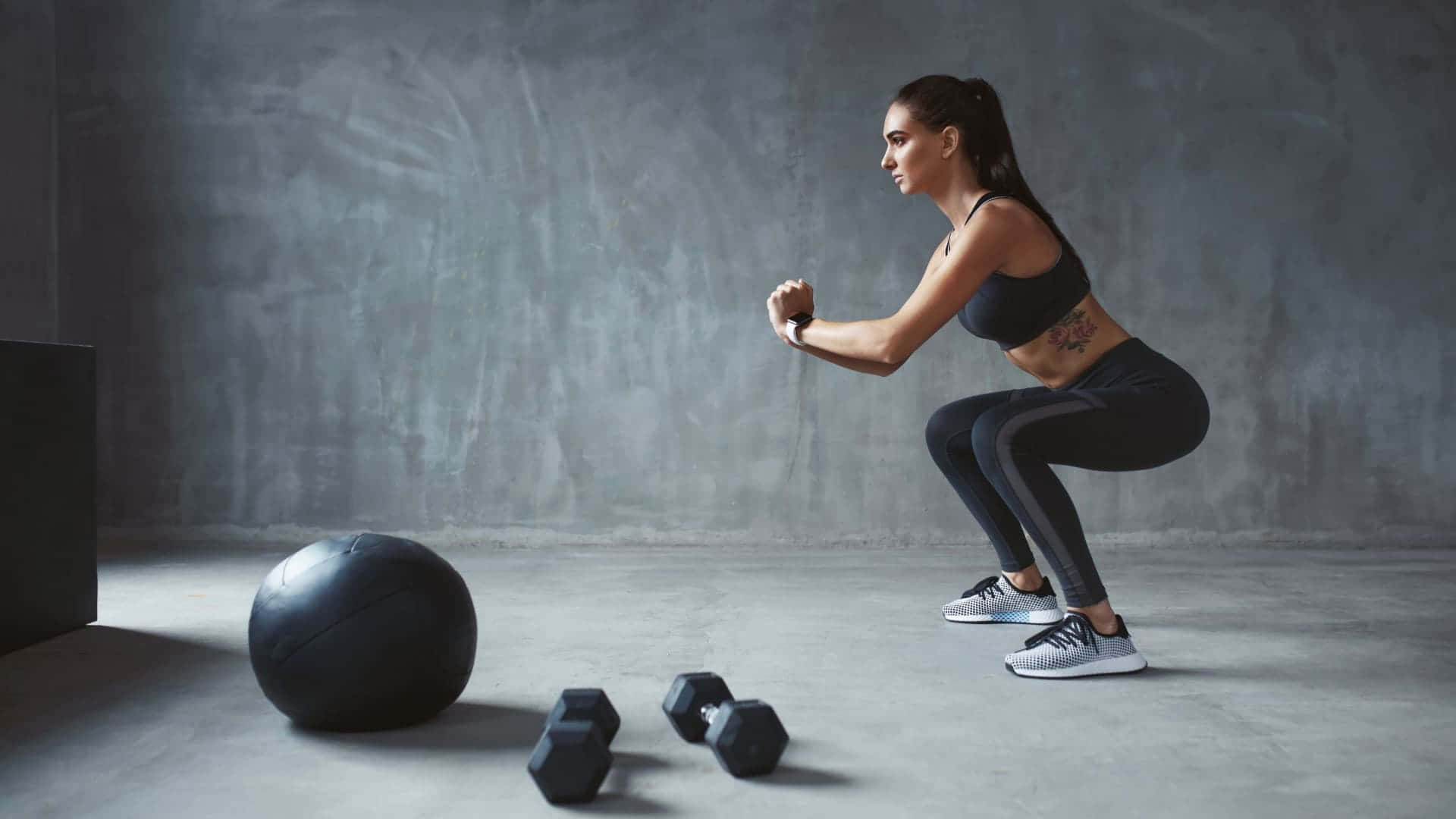 A Woman Is Doing Squats With A Ball And A Weight Wallpaper