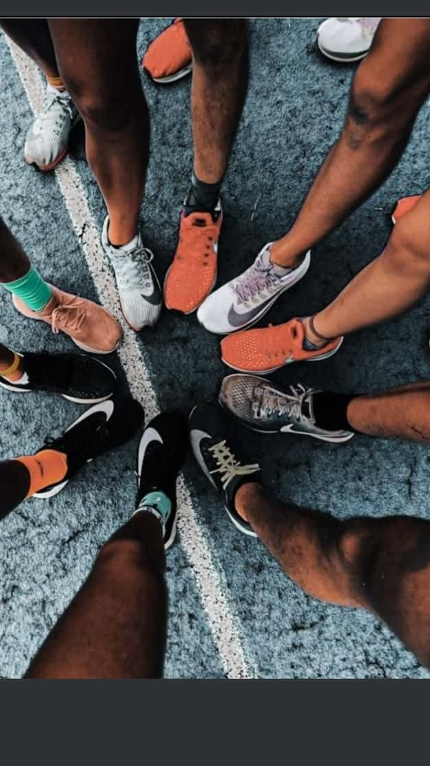 A Group Of People Standing In A Circle With Their Shoes On Wallpaper
