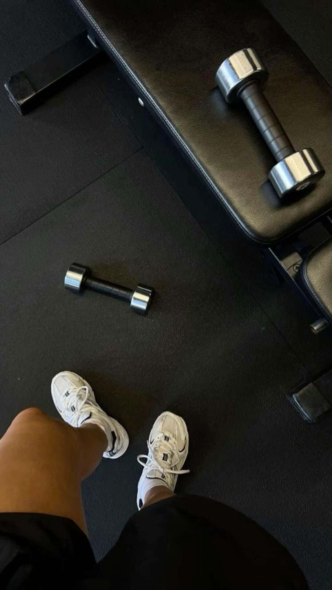 a person's feet are on a bench with dumbbells Wallpaper