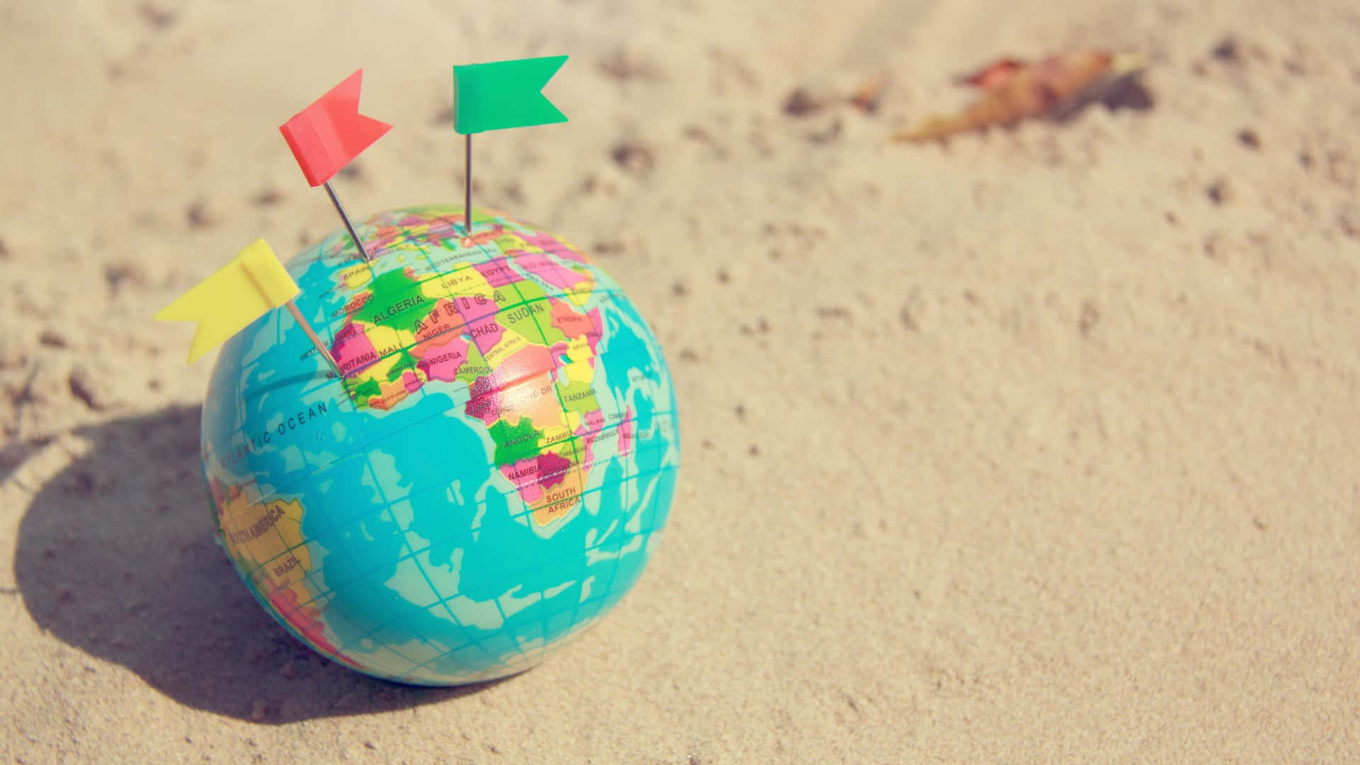 Flags On Globe By The Sand Travel Background