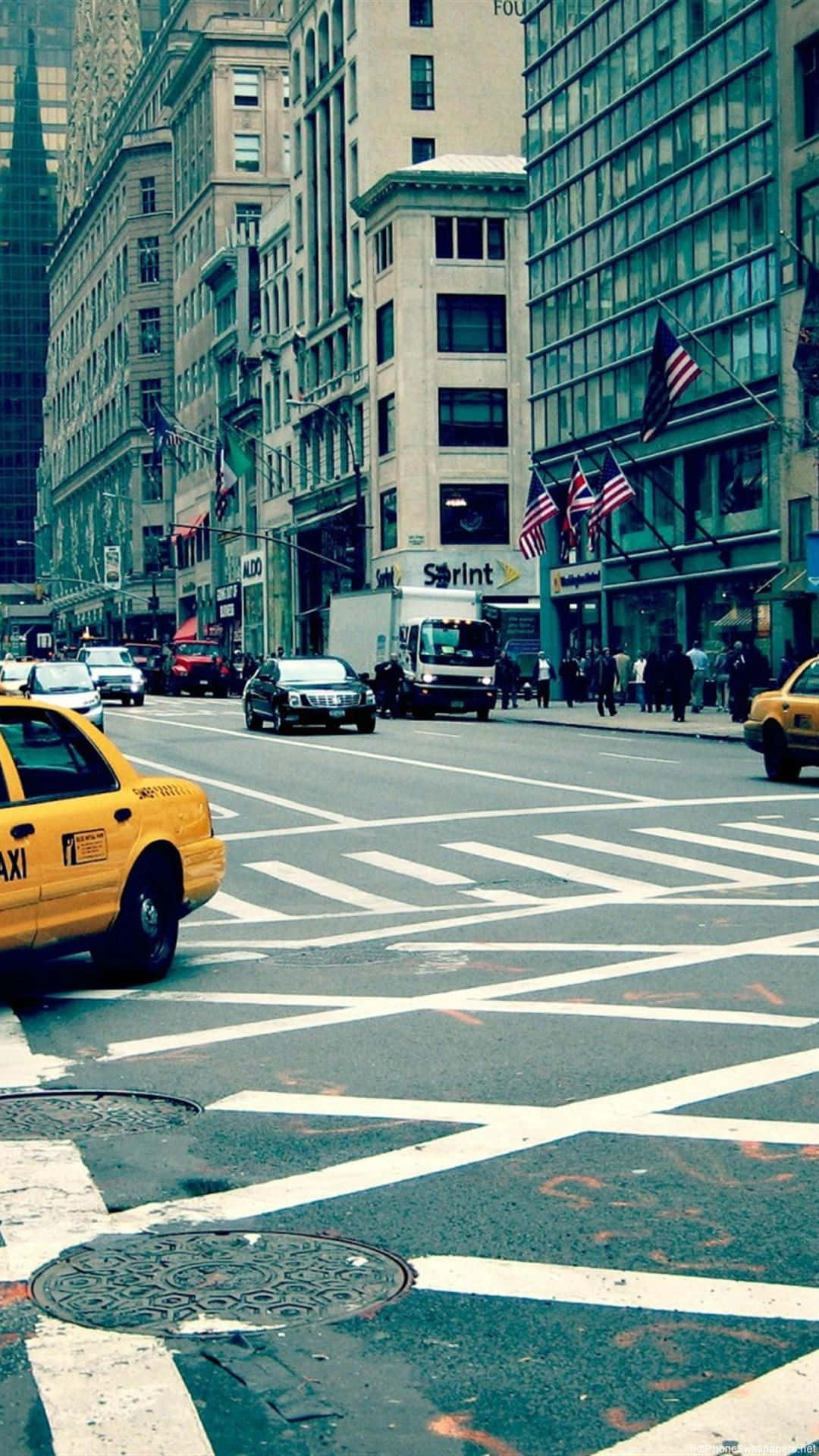 En gul taxa kører ned ad en gade. Wallpaper