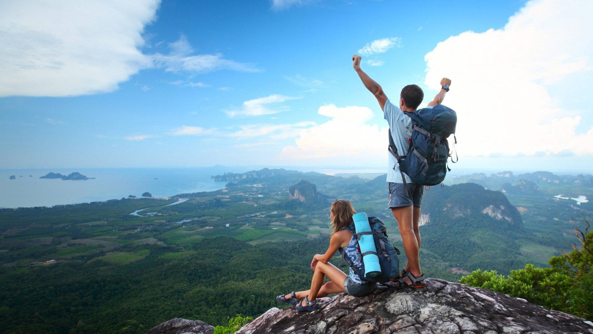 Two People With Backpacks On Top Of A Mountain Wallpaper