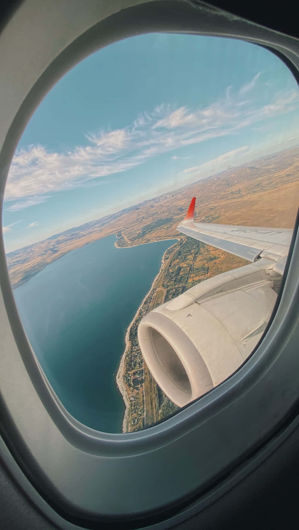 an airplane window with a view of a lake