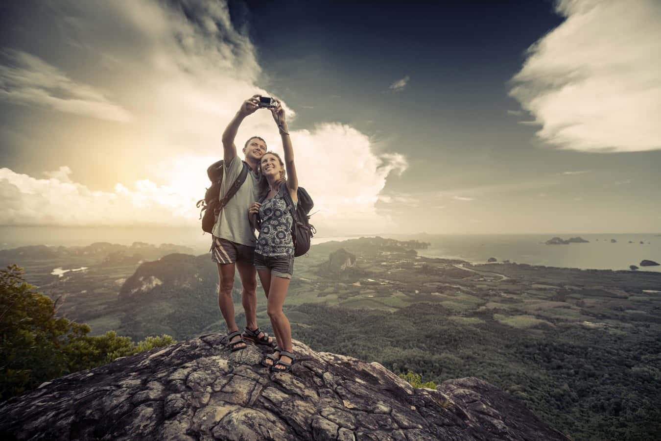 two people taking a picture on top of a mountain