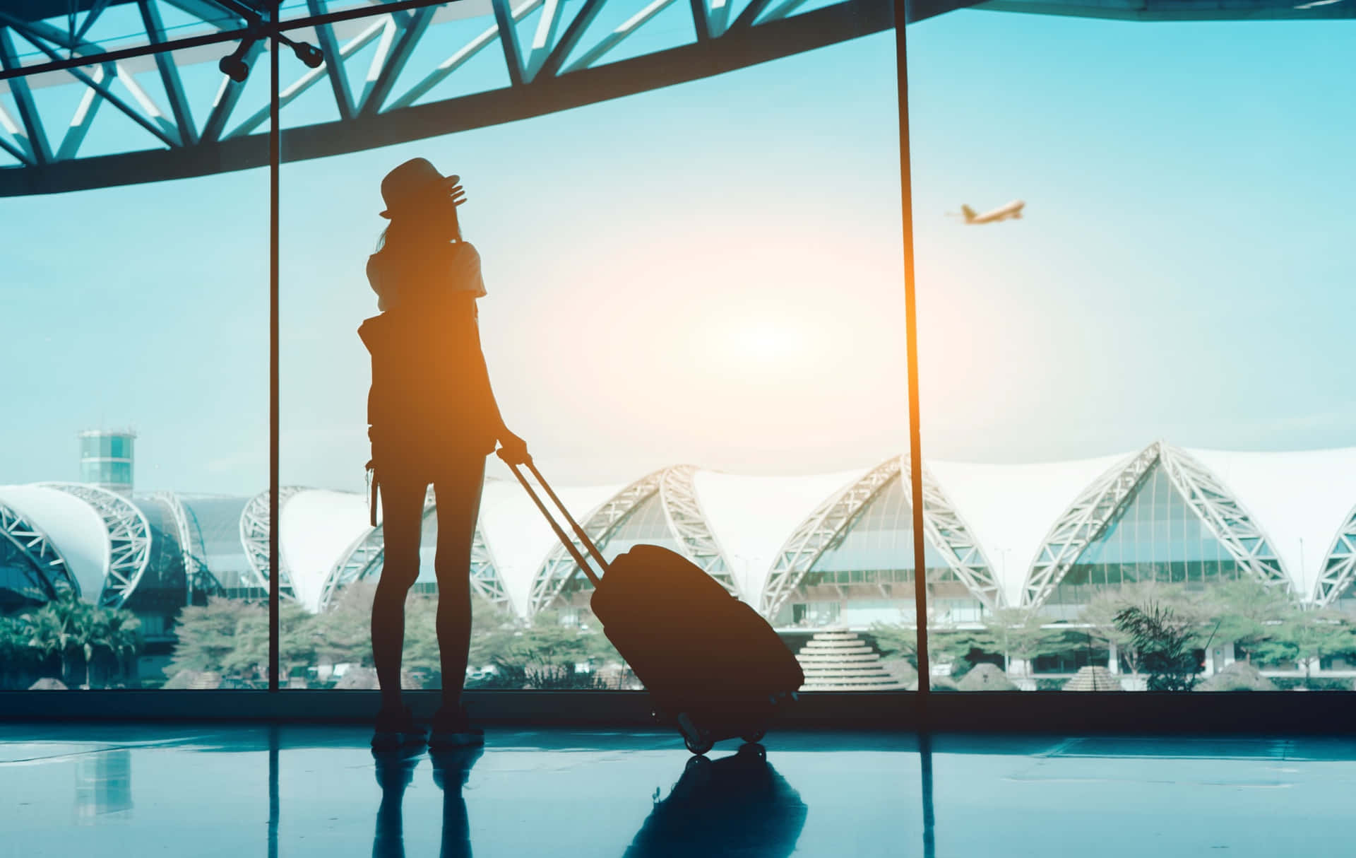 silhouette of woman with luggage at airport
