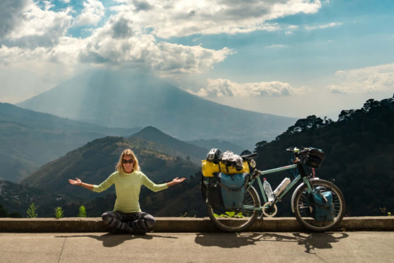 a woman is sitting on a bike in front of a mountain