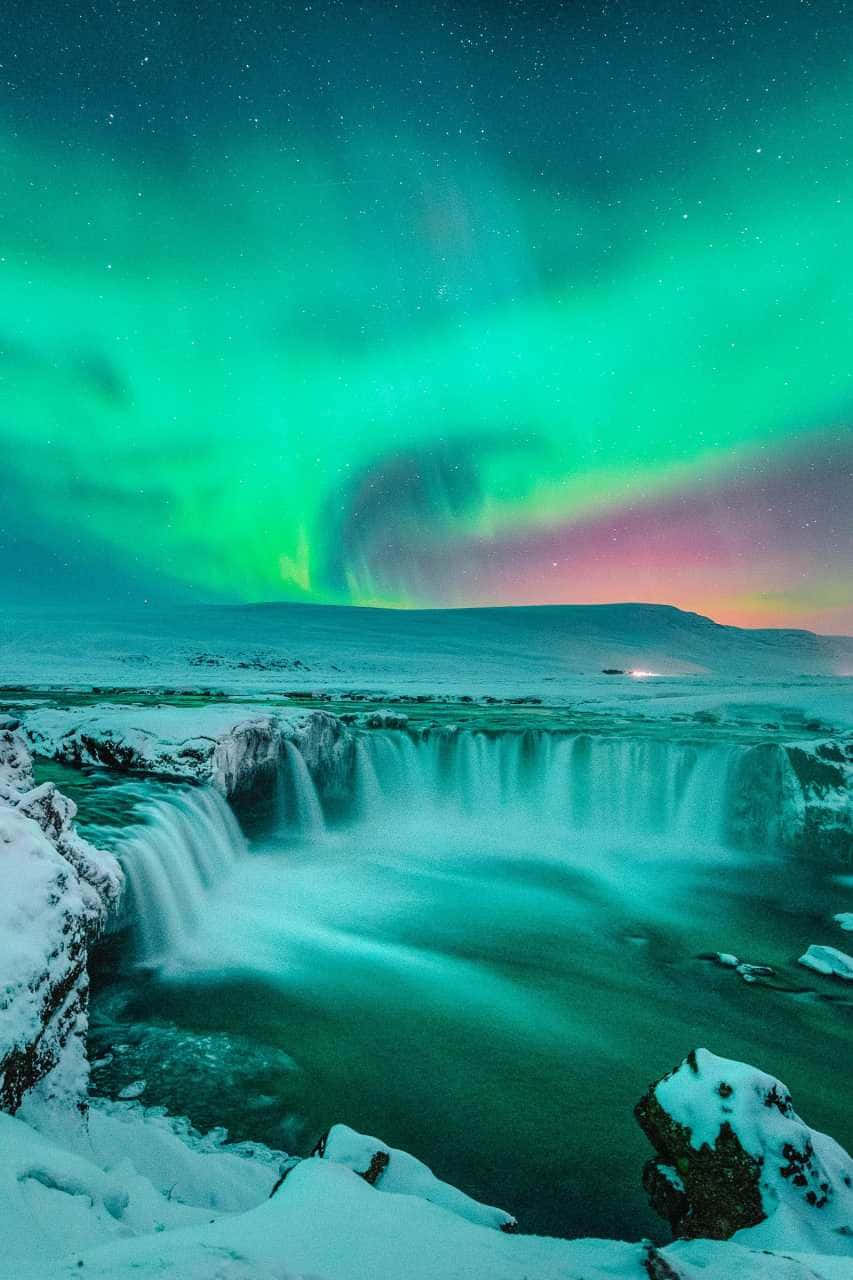 A Waterfall With The Aurora Borealis Over It