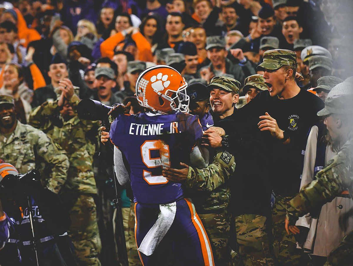 Travis Etienne Celebration With Military Personnel Wallpaper