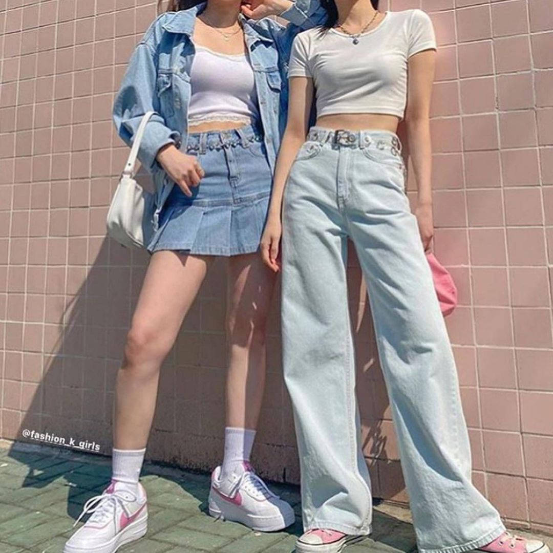 Two Women Wearing Denim Jeans And Sneakers Wallpaper