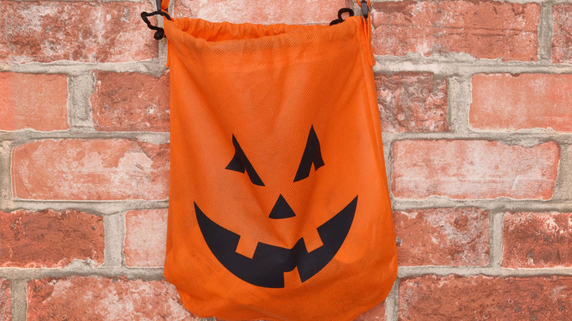 A pile of colorful Trick or Treat bags ready for Halloween night Wallpaper