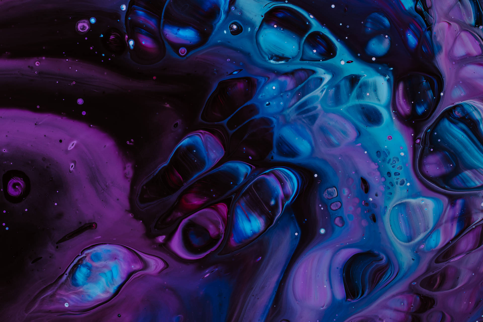 Trippy purple and blue water droplets on smooth surface wallpaper.