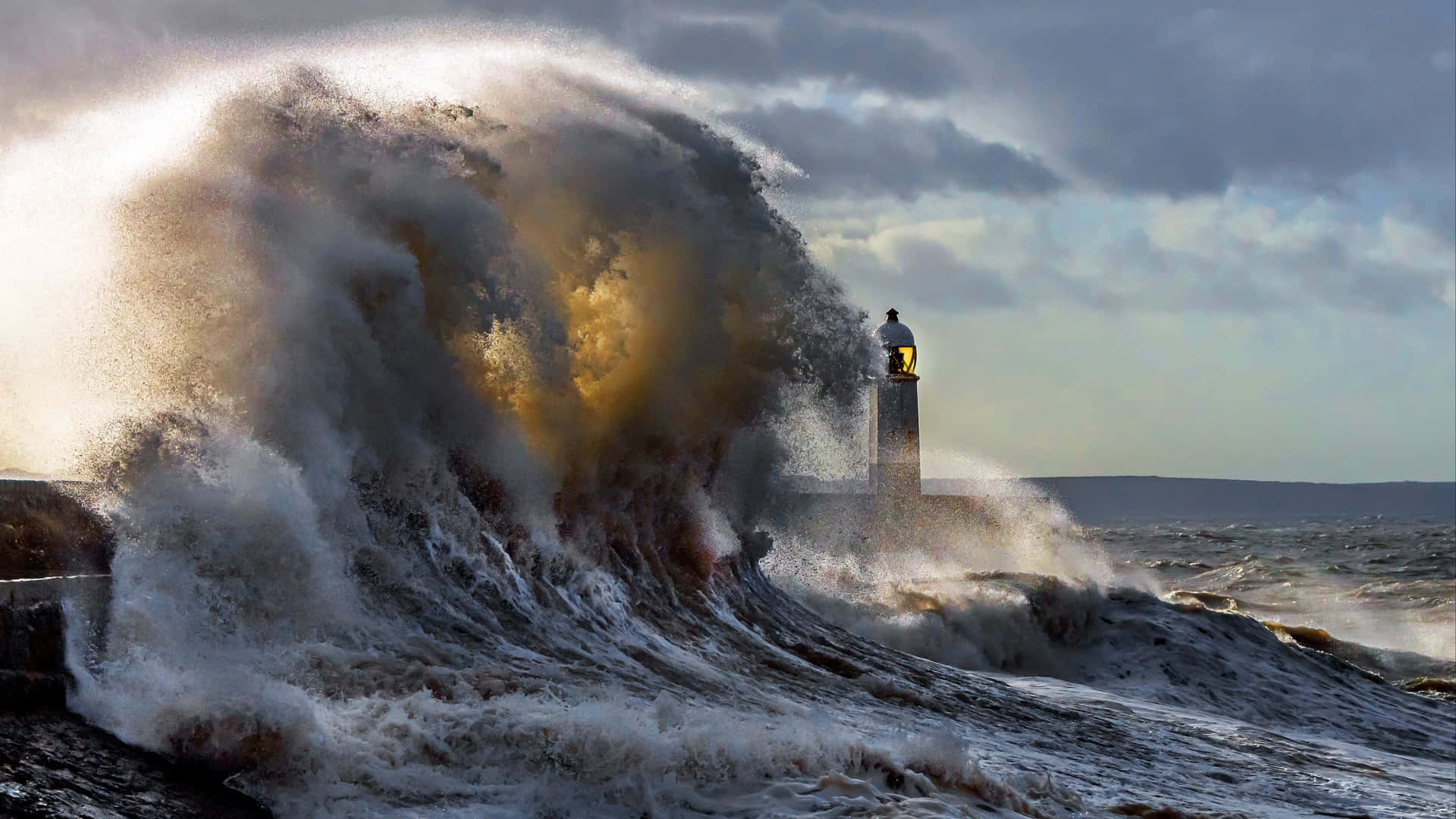 A Large Wave Crashes Into A Lighthouse