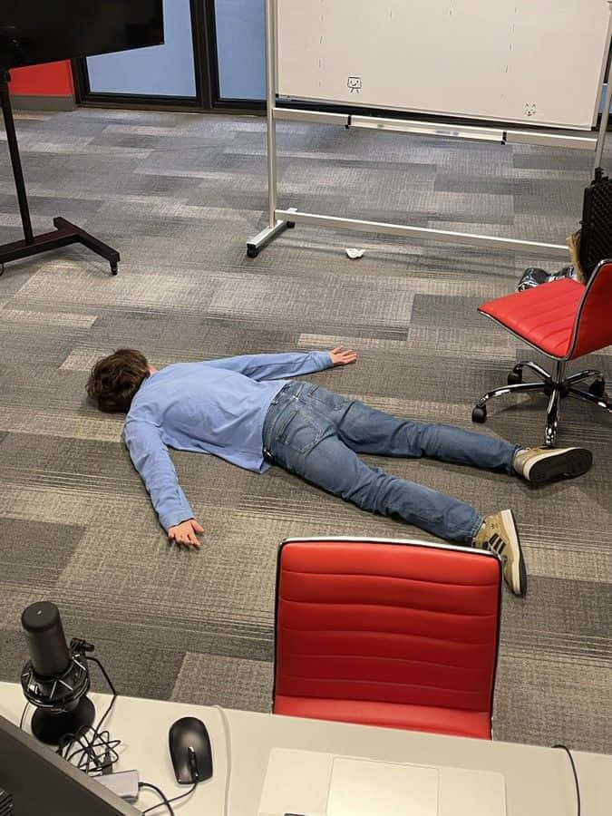 A Man Laying On The Floor In An Office