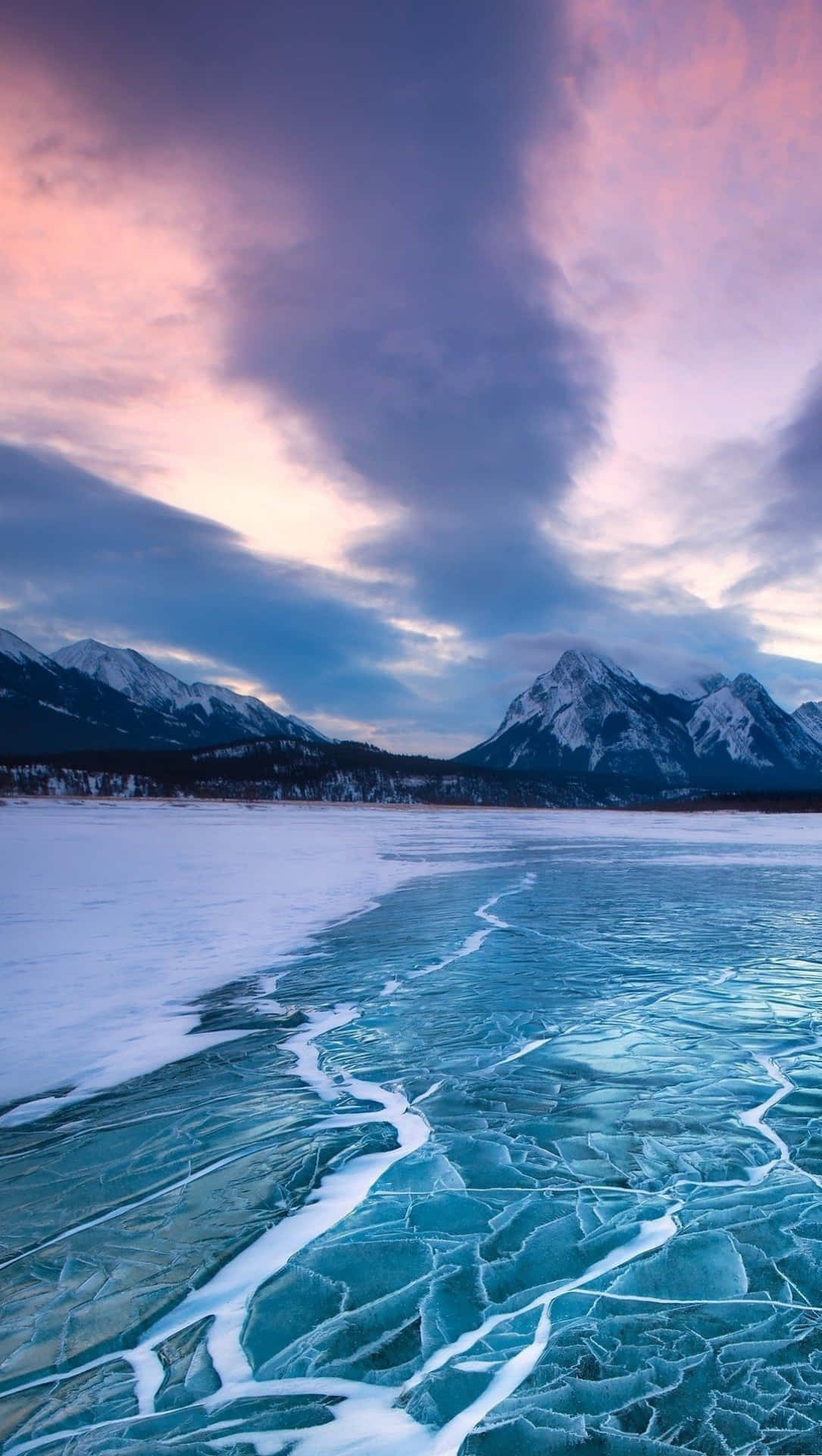 A Frozen Lake With Mountains In The Background