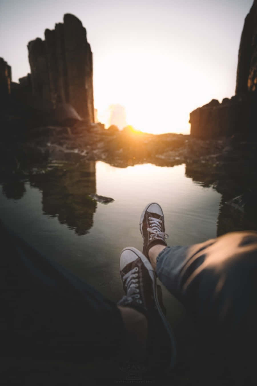 Diefüße Einer Person Sitzen Bei Sonnenuntergang Im Wasser.