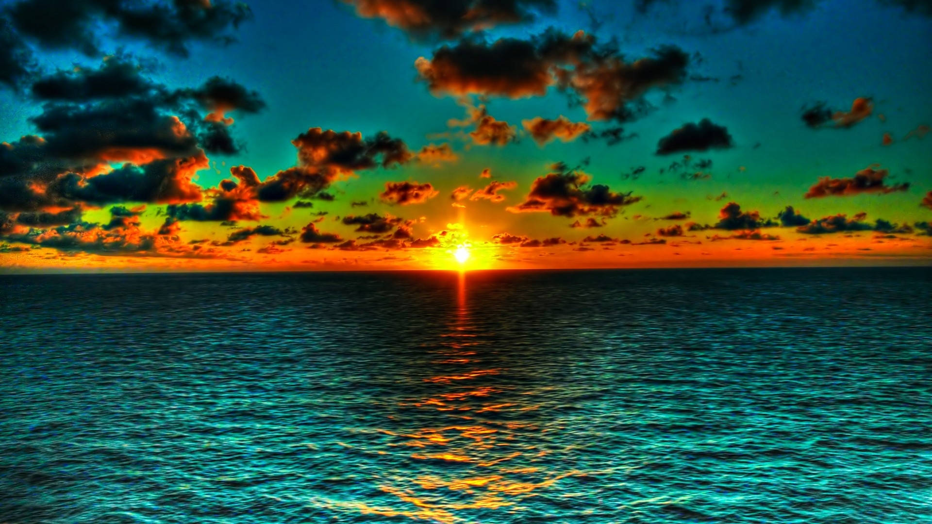 the sun is setting over the ocean Wallpaper