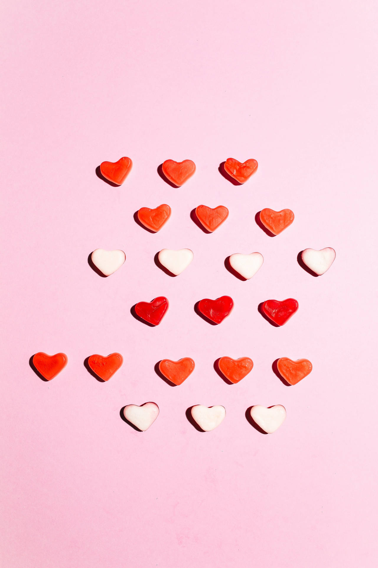 A Pink Background With Red And White Hearts Wallpaper