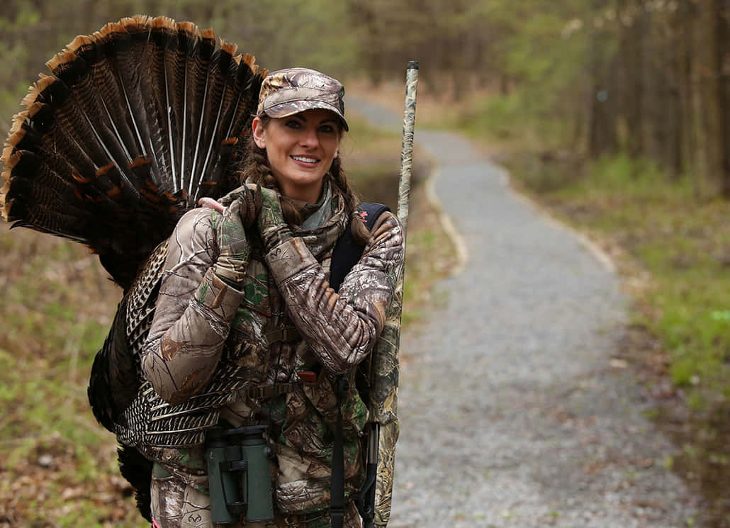 An avid hunter proudly displays the results of a successful turkey hunt. Wallpaper