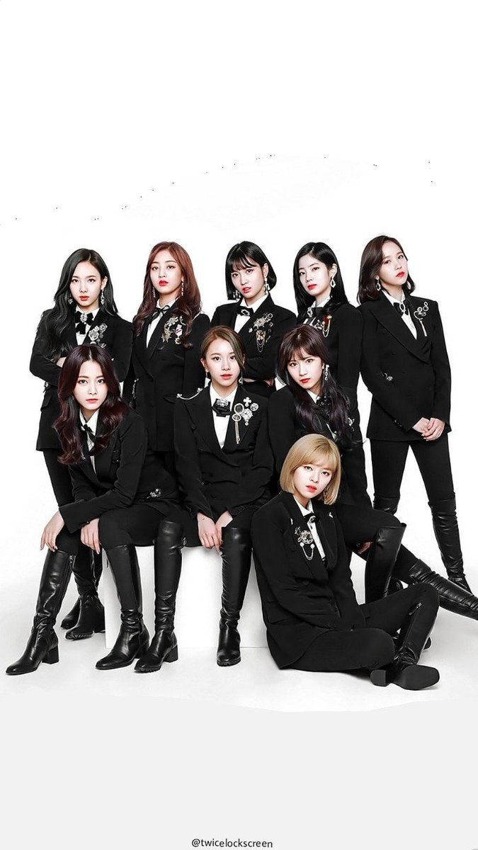 TWICE takes their talents to the stage in smart black suit looks! Wallpaper — Nine women in matching black suits with floral brooches pose confidently against a stark white background.
