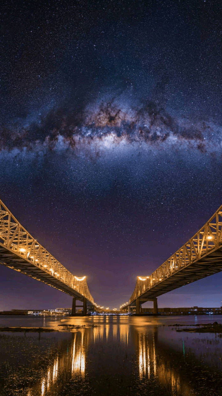 Twin Bridges Under A Galactic Night Sky Wallpaper