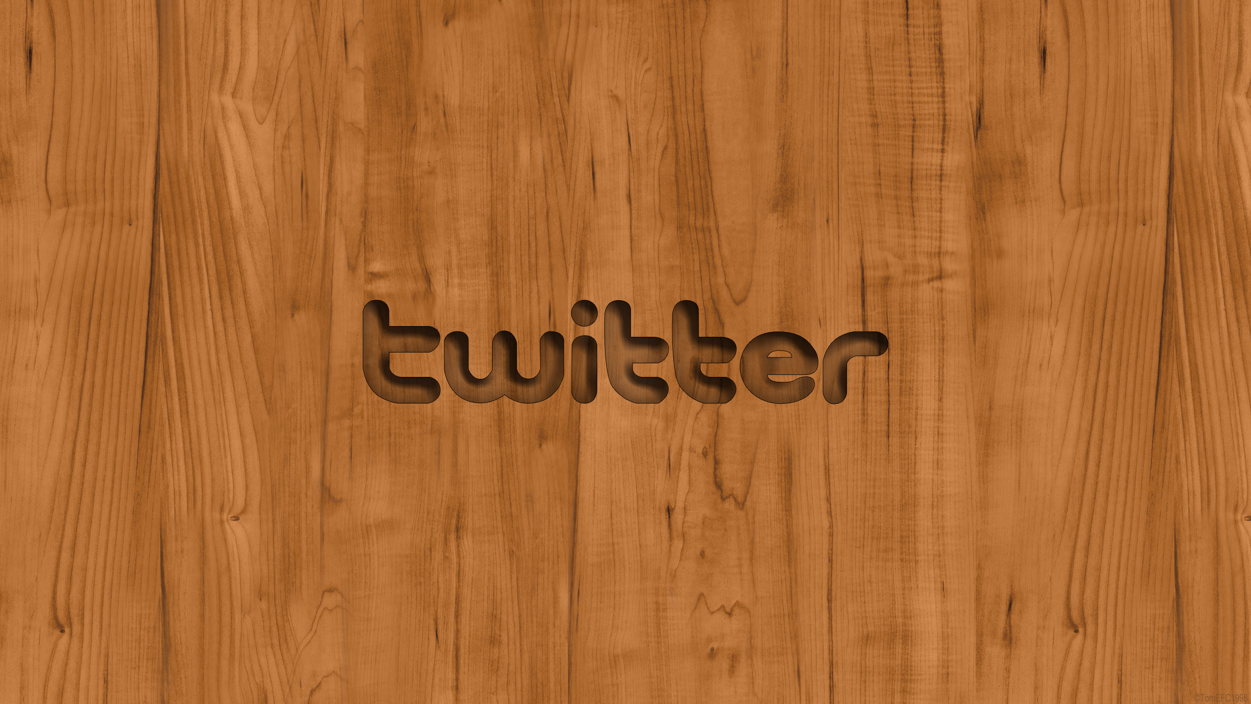 Discover new conversations and fresh perspectives to engage in Background — The word twitter is carved into a warm brown wooden surface with visible grain patterns.