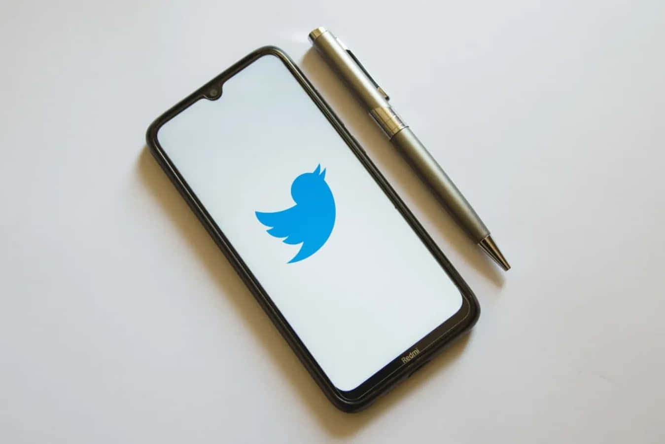 Twitter Logo On A Smartphone With A Pen