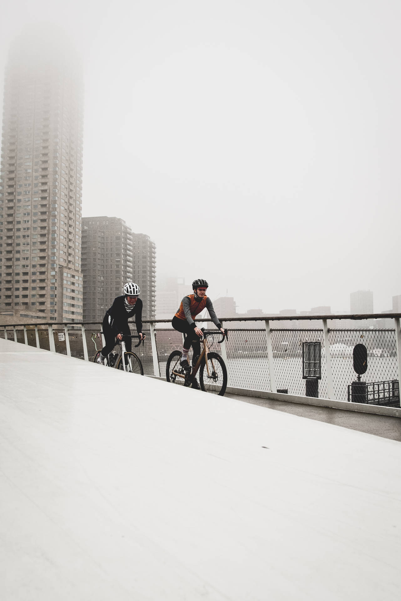Dosmujeres En Bicicleta En Un Puente De La Ciudad Fondo de pantalla
