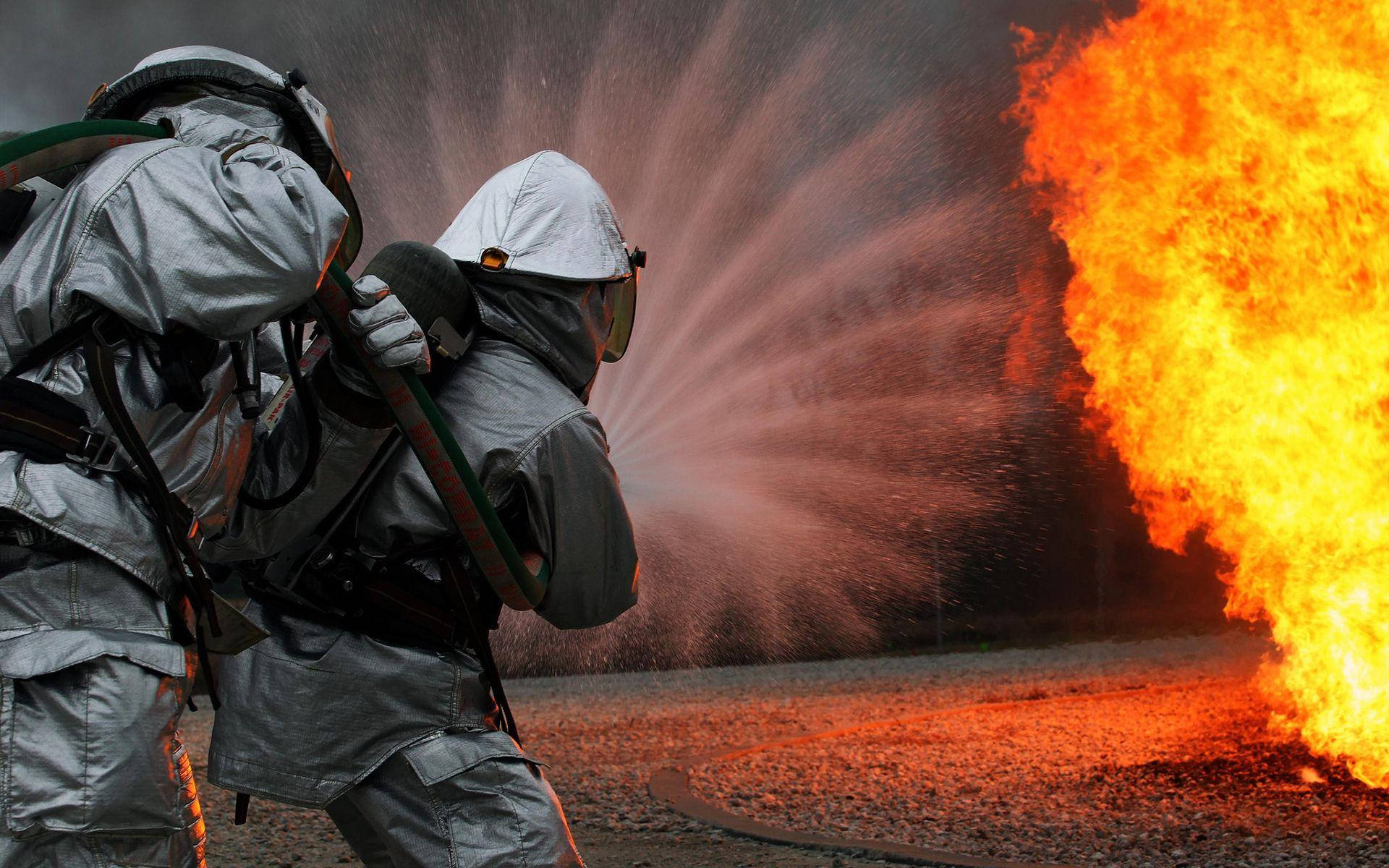 Two Firefighters Applying Water To Fire Wallpaper