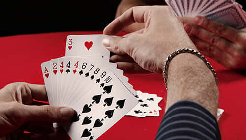 Two Players Playing Gin Rummy On A Red Table Wallpaper