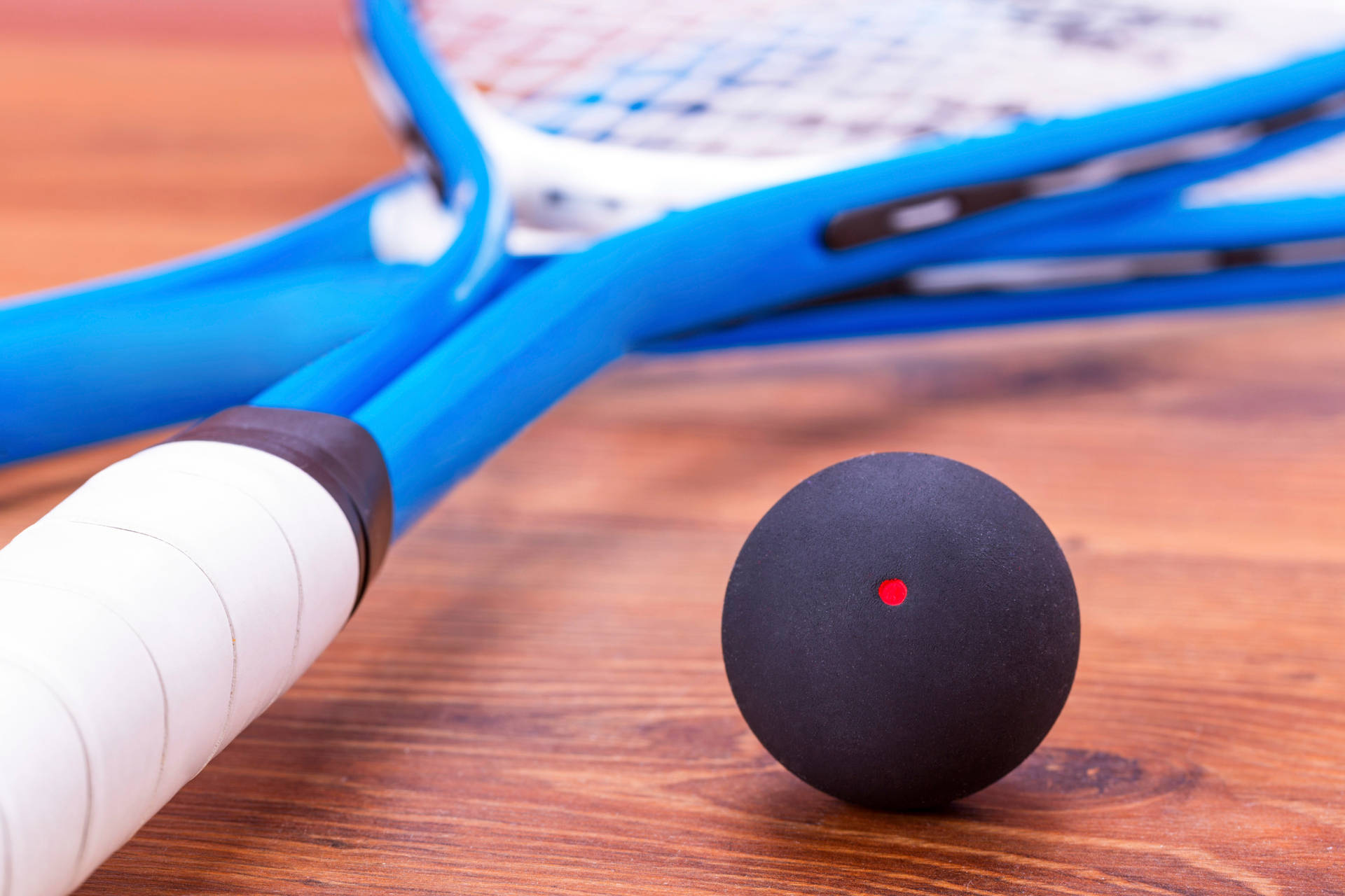 Two Racquetball Rackets and Ball on Court Wallpaper