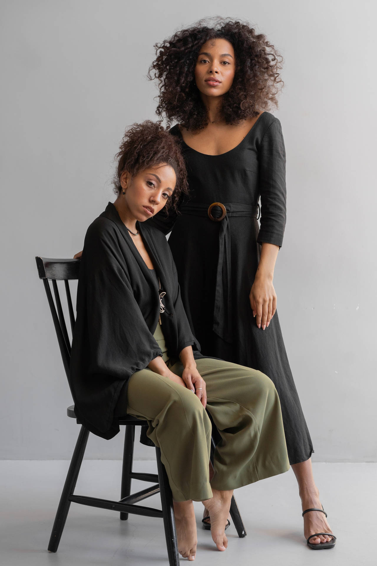 Two Sexy Black Women Modeling On A Chair Wallpaper