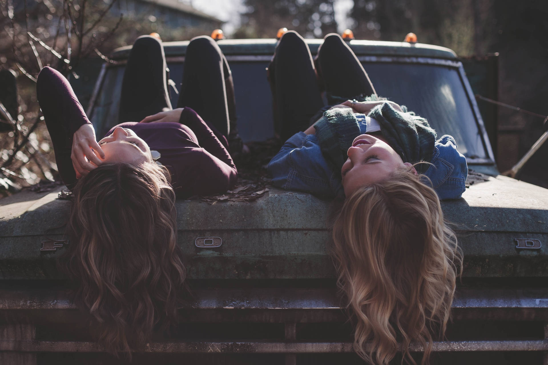 Two Teenage Girls Lying On The Car Wallpaper
