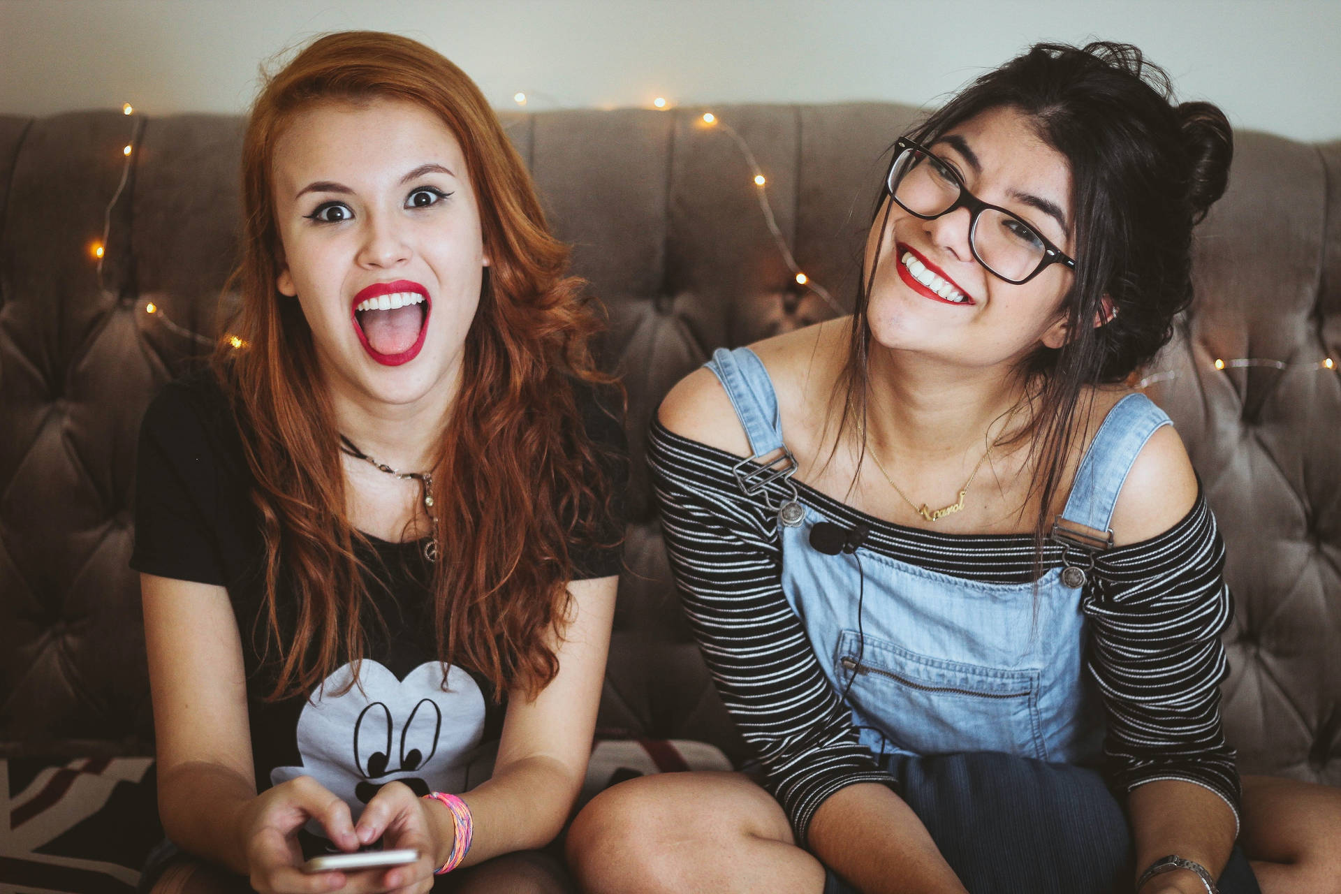 Two Teenage Girls Sitting At The Sofa Wallpaper