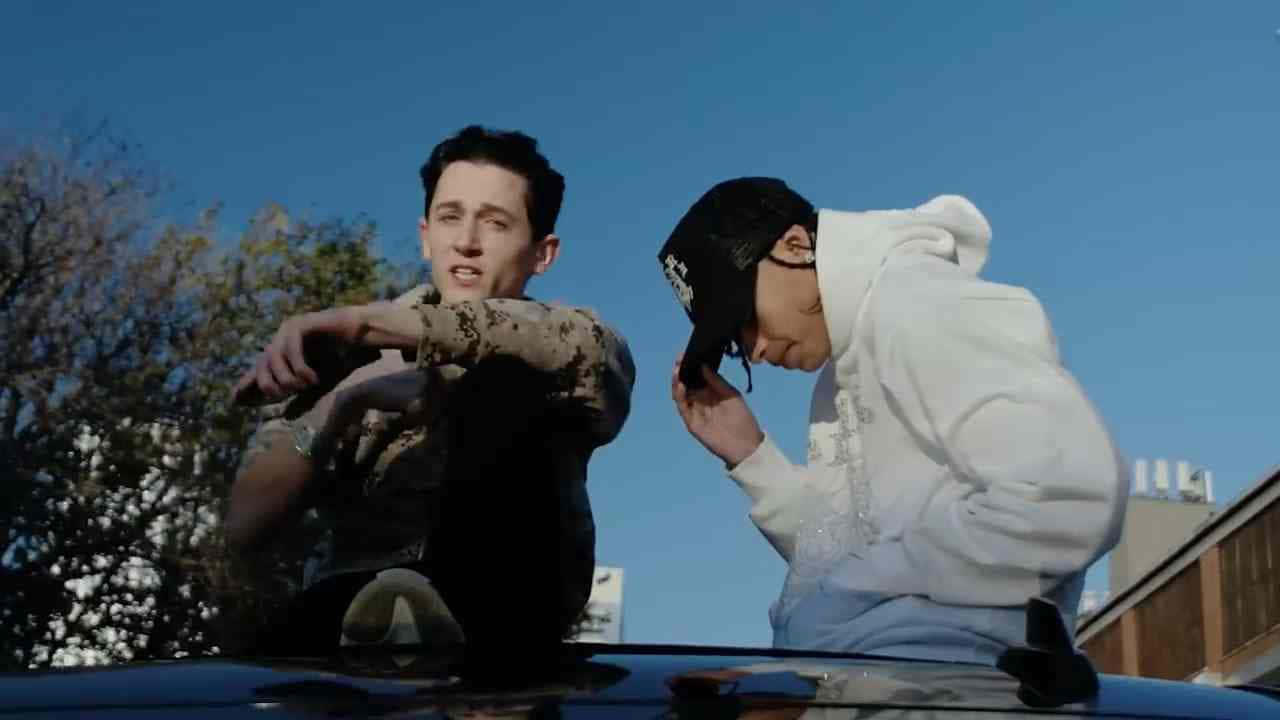 Two Young Men Sittingon Car Roof Wallpaper