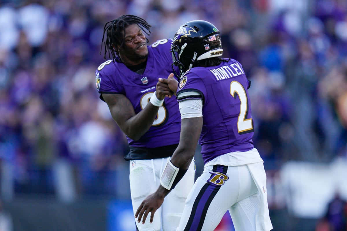 Tyler Huntley Celebratingwith Teammate Baltimore Ravens Wallpaper