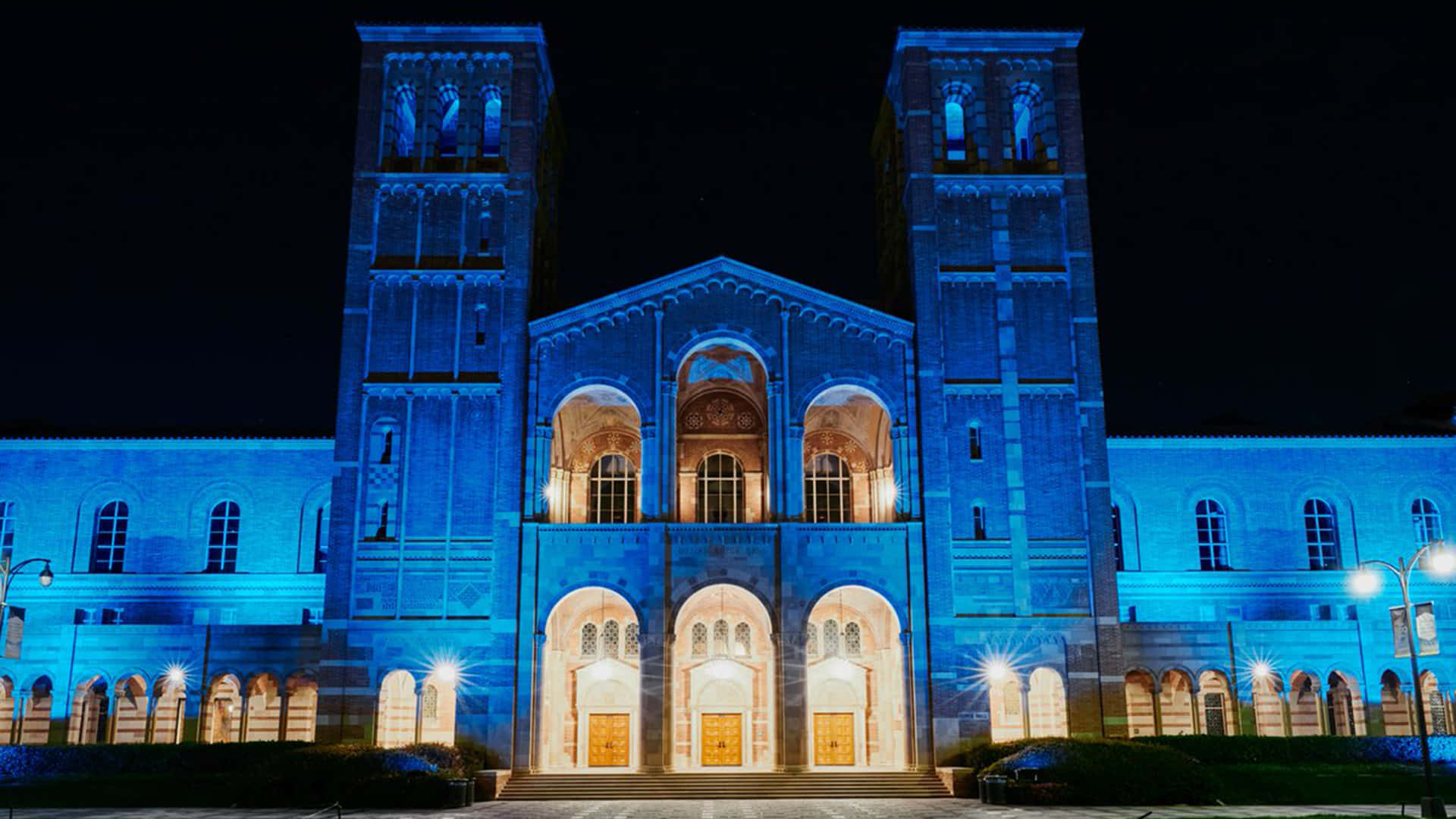 Et stort bygning oplyst i blå og lilla Wallpaper