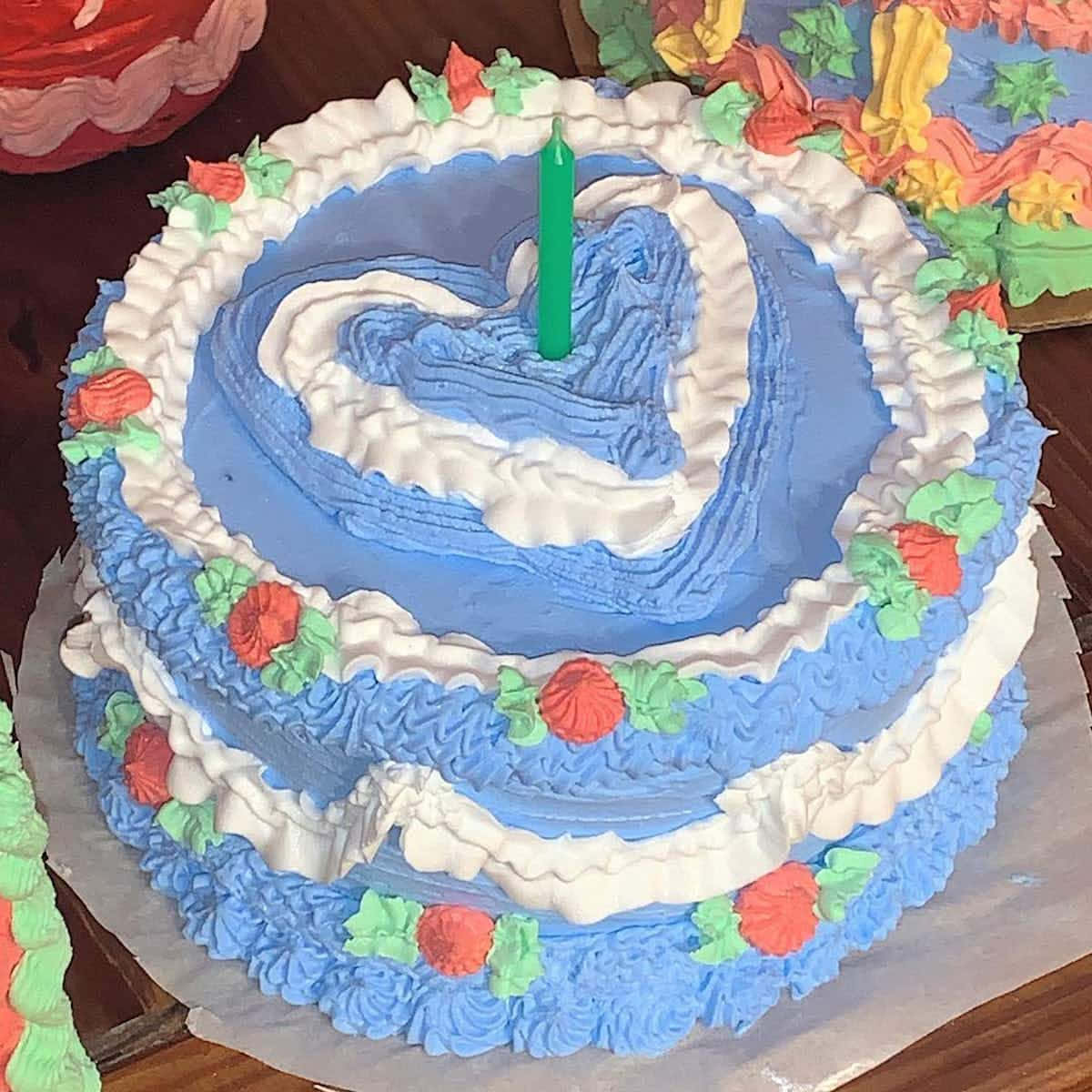 A Blue And White Cake With A Candle
