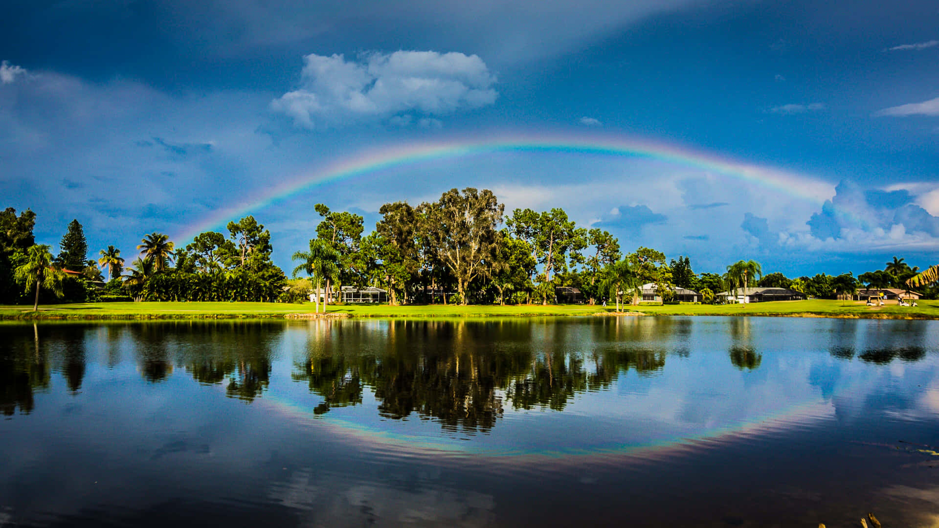 A Rainbow Is Reflected In A Lake