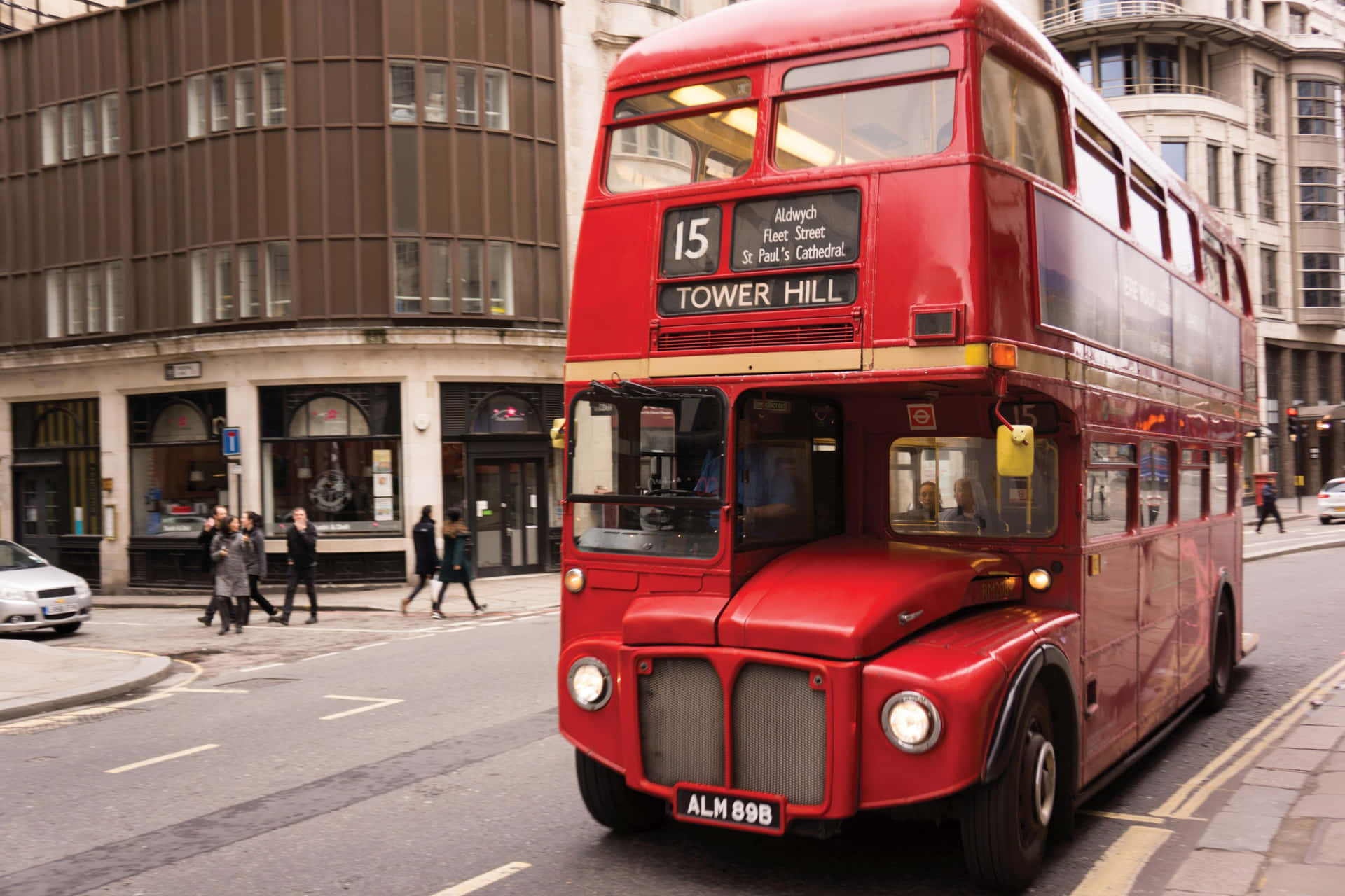 A Red Double Decker Bus Is Driving Down The Street