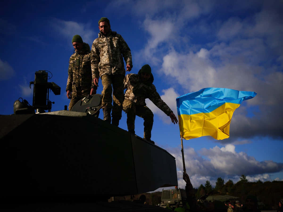 Ukrainskesoldater Står På Toppen Af En Tank Med Et Flag Som Baggrundsbillede Til Computeren Eller Mobiltelefonen.