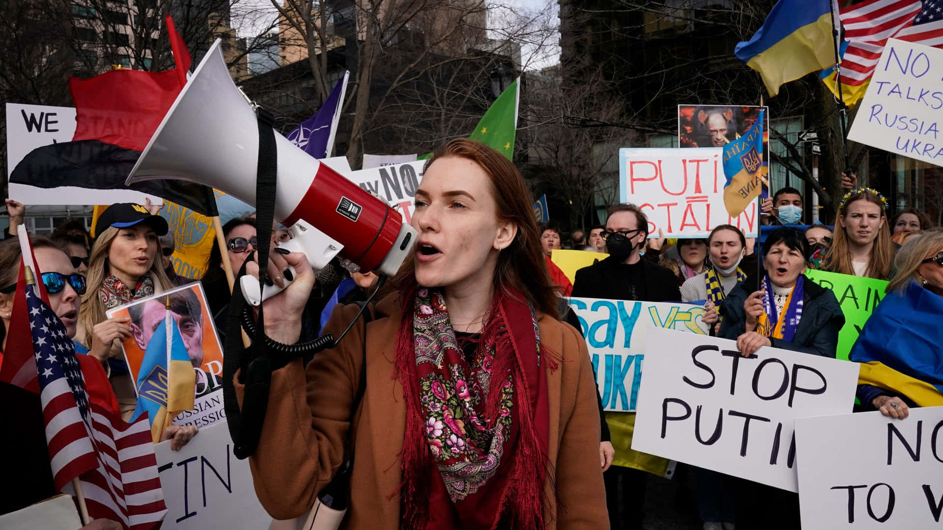 A Woman Holding A Megaphone And Signs