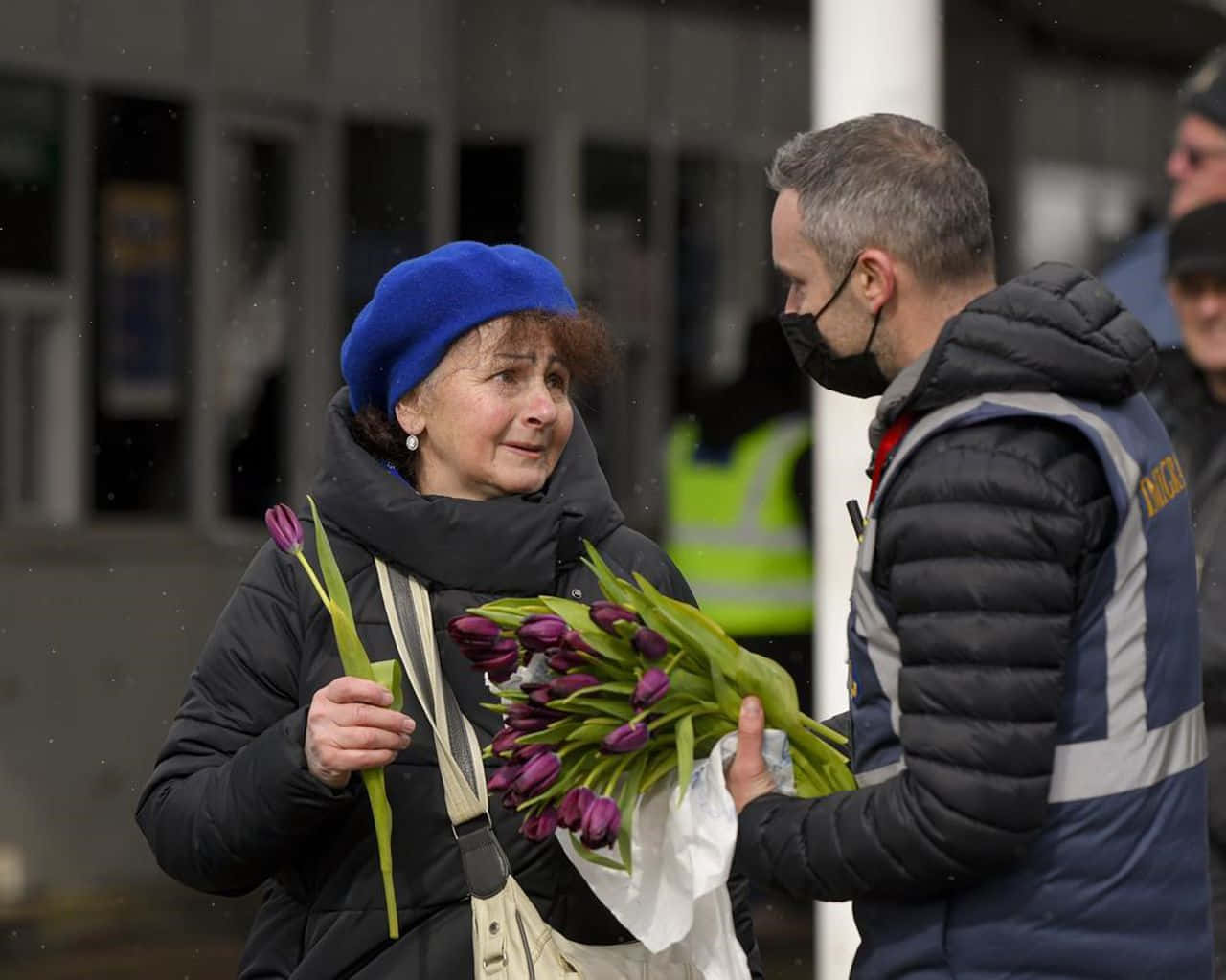 A Man And Woman Are Holding Flowers
