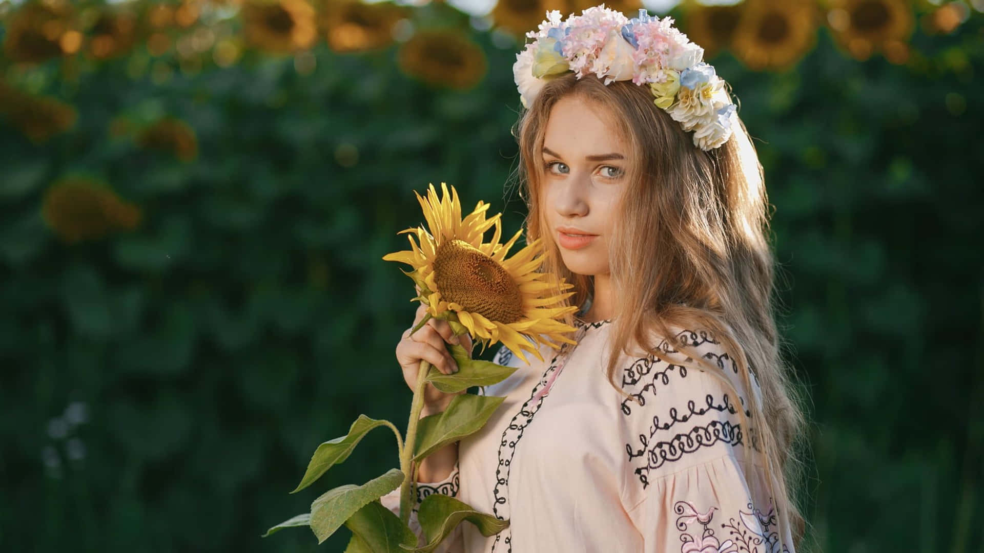 A Girl In A Flower Crown Holding A Sunflower