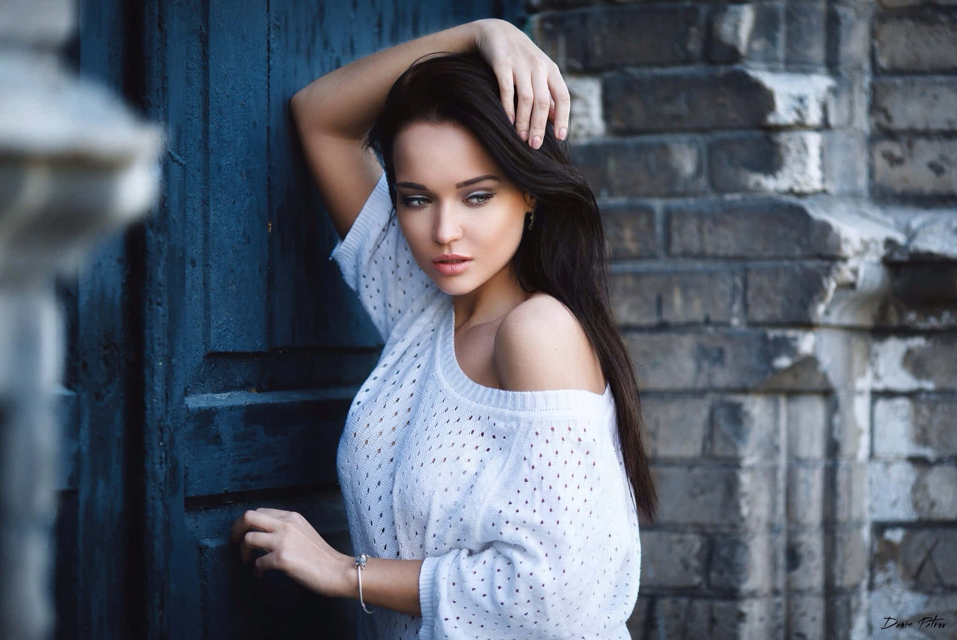 Beautiful Young Woman Posing In Front Of A Blue Door