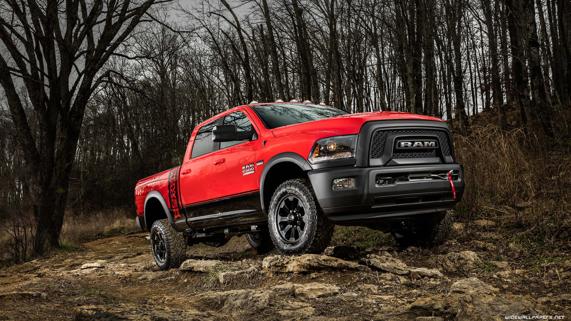 A Red Ram Truck Driving On A Rocky Trail Wallpaper
