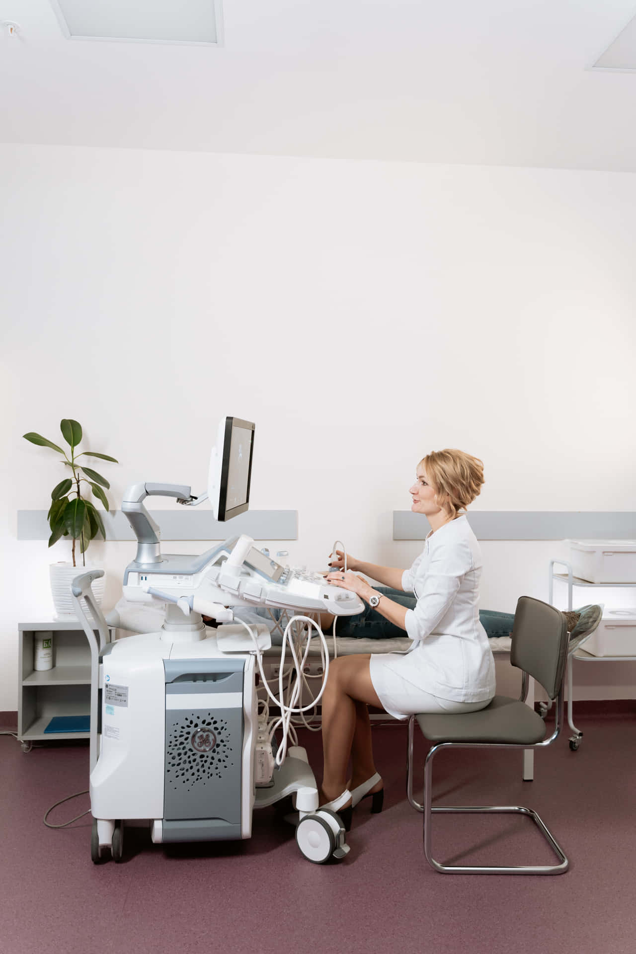 A Woman In A White Dress Is Sitting At A Desk
