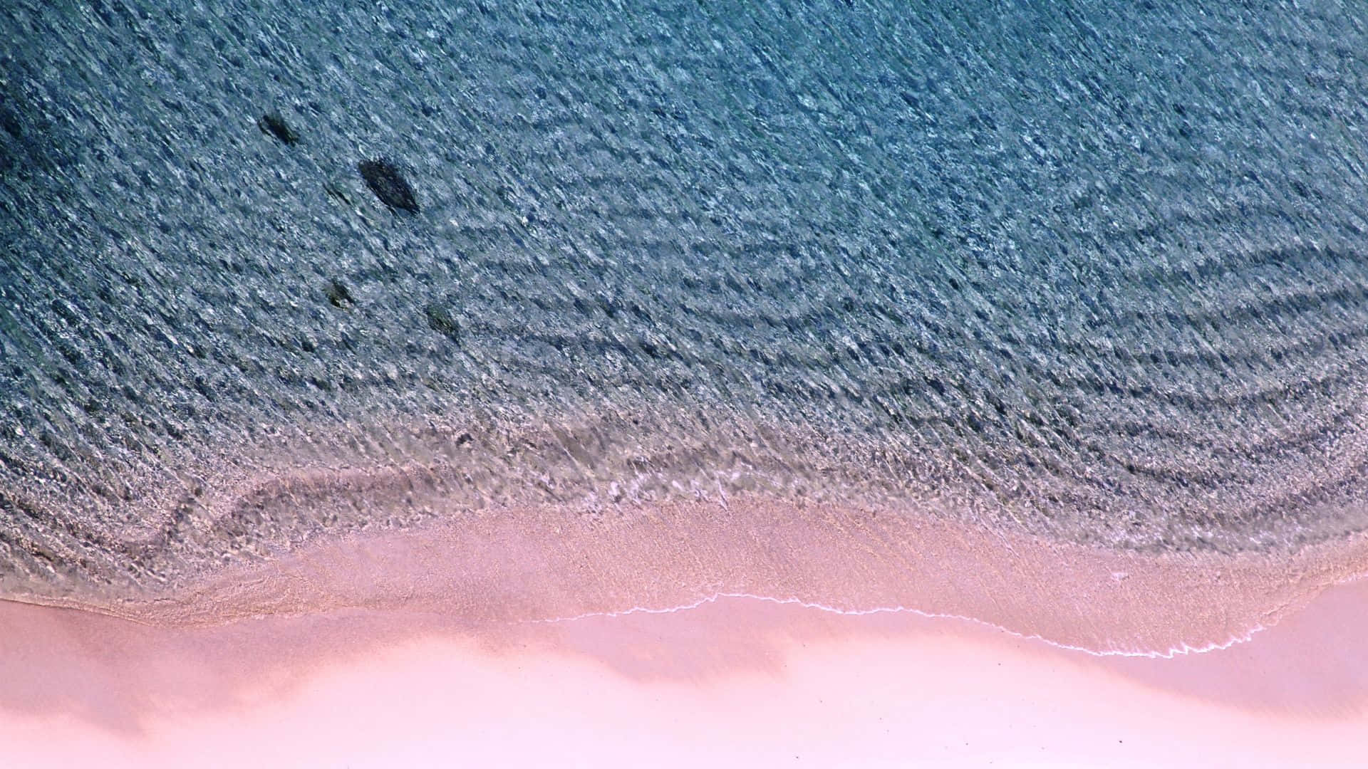Unavista Cautivadora De La Playa Rosada Con Aguas Cristalinas De Color Azul Y Costas De Arena Blanca. Fondo de pantalla