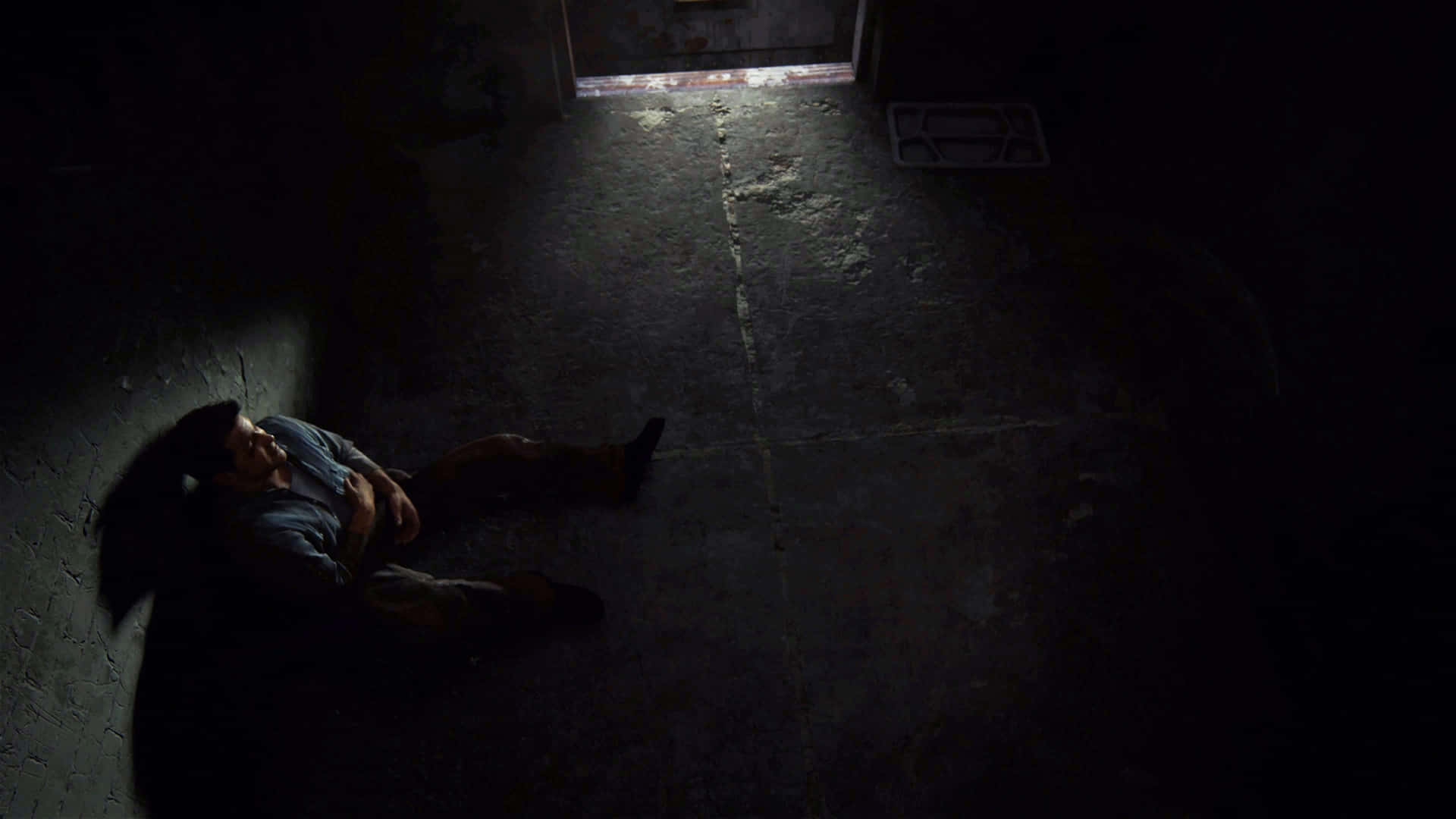 A Man Laying On The Floor In A Dark Room Wallpaper